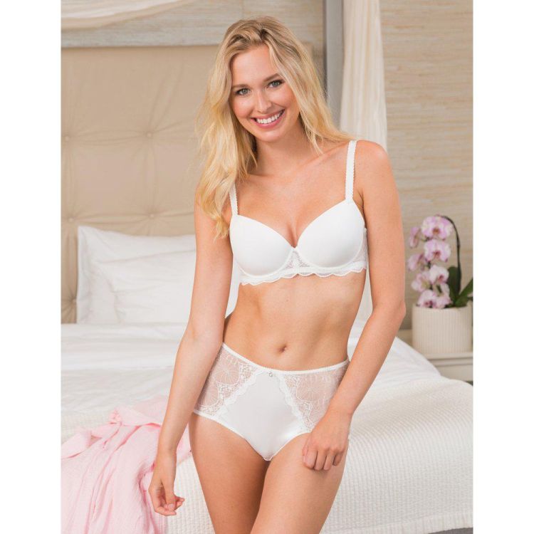 Plussize hvid blonde-BH og matchende trusser præsenteret i et lyst soveværelsesmiljø.