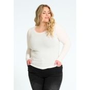 Langærmet, hvid plussize trøje med rund hals, præsenteret sammen med sorte bukser, ideel til både afslappet og formelt brug.