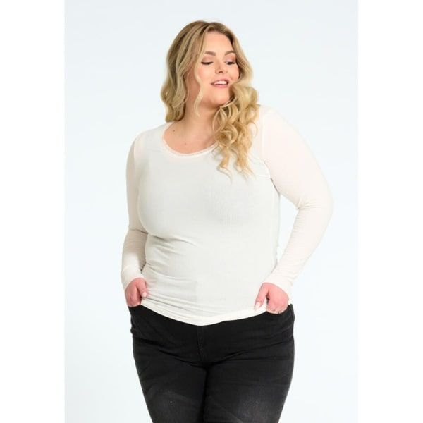 Langærmet, hvid plussize trøje med rund hals, præsenteret sammen med sorte bukser, ideel til både afslappet og formelt brug.