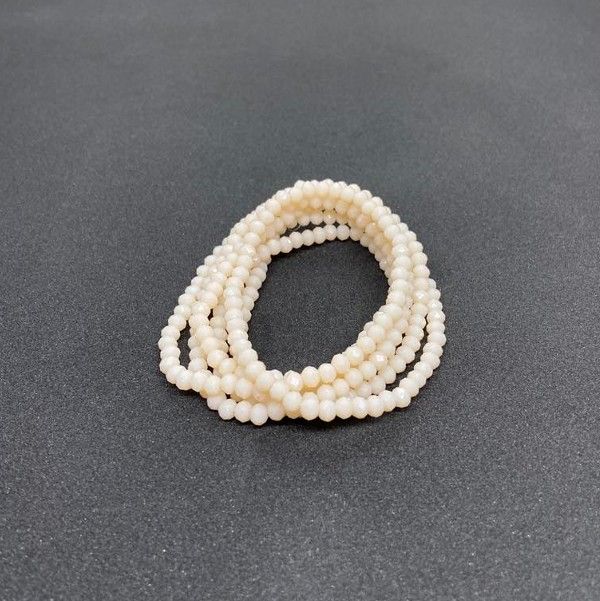 Perlehalskæde lagt i løkker på en mørk baggrund, velegnet til elegant tilbehør.