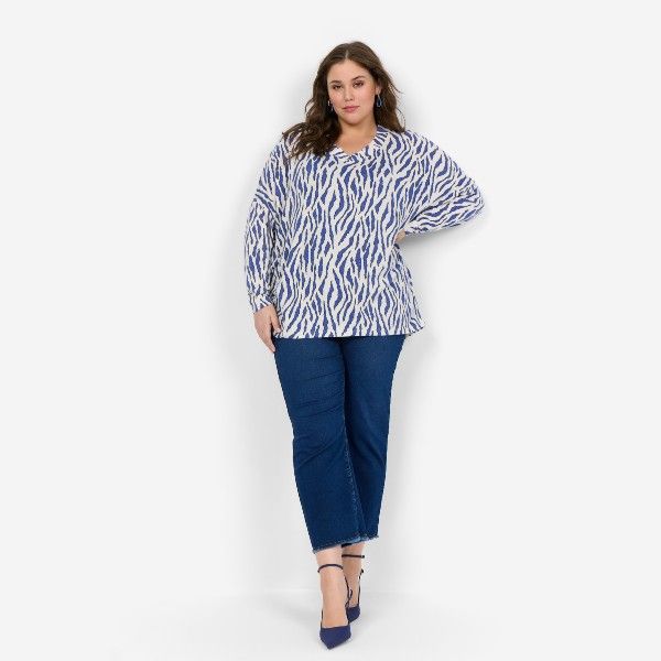 Elegant plussize outfit med zebra-stribet bluse og mørkeblå jeans, perfekt til stilbevidste kvinder. Komfort møder mode.