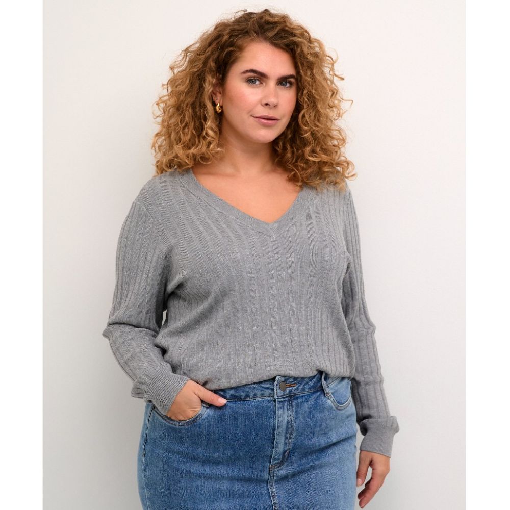 Moderne grå striktrøje i plussize med V-hals og længe ærmer, kombineret med blå jeans. Perfekt til hverdagsbrug.