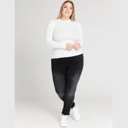 Moderigtig plussize outfit med en hvid langærmet top og sorte skinny jeans, kombineret med hvide sneakers.