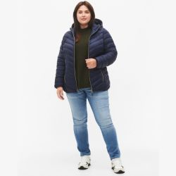 Plussize marineblå dynejakke med hætte kombineret med en olivengrøn striktrøje og lyseblå denim jeans, perfekt til køligere dage.