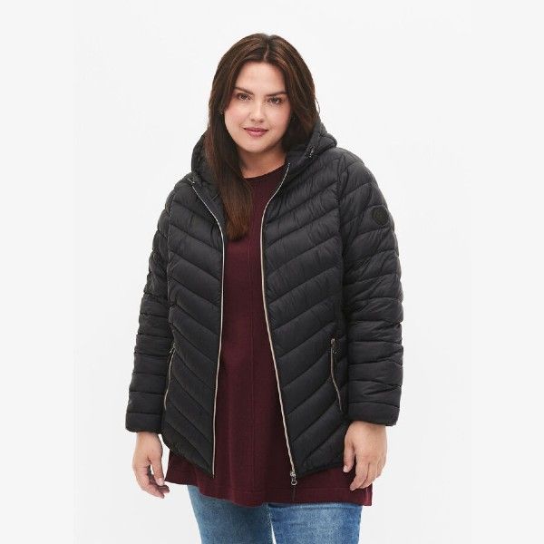 Sort quiltet jakke med hætte i plussize, fremhævet med lynlåsdetaljer, ideel til køligere vejr.