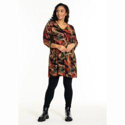 Plussize tunika med grafisk mønster, lange ærmer og V-udskæring, præsenteret med sorte leggings og ankelstøvler.