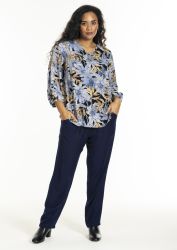 Plussize blomstret bluse med lange ærmer og marineblå løstsiddende bukser, stylet med sorte ankelstøvler.