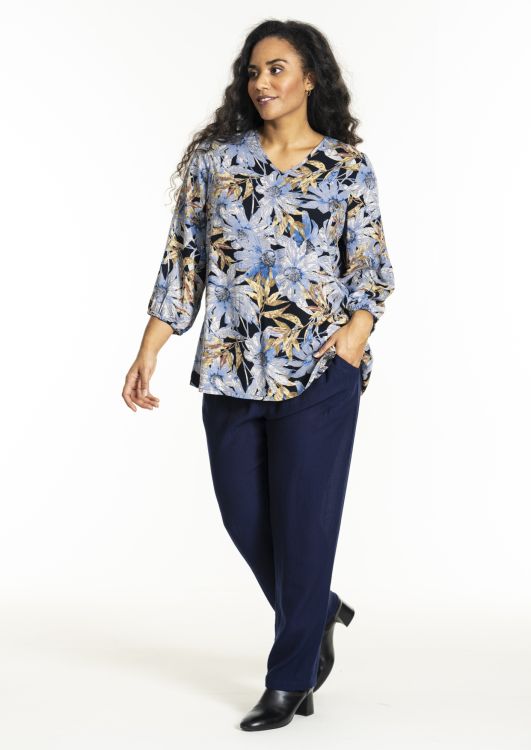 Blomsterprintet tunika i plussize med 3/4-ærmer og matchende mørkeblå bukser, stylet med sorte ankelstøvler.