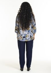 Mønstret bluse med blade og mørke bukser til plussize; bagfra visning til modekatalog.