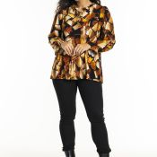 Mønstret bluse i efterårsfarver og sorte slim-fit bukser med sorte ankelstøvler på hvid baggrund.