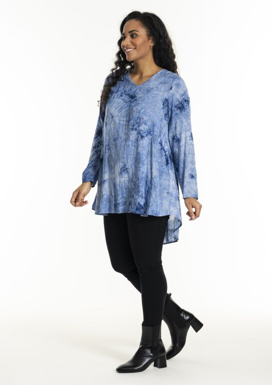 Blå tunika med mønster, kombineret med sorte leggings og ankelstøvler, viser en moderne plussize stil til hverdagsbrug.