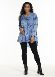 Plussize tunika i blå batik med V-hals, parret med sorte stramme bukser og sorte ankelstøvler for en stilsikker fremtoning.