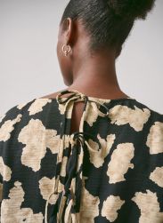 Elegant mønstret overdel med bånddetalje i nakken og guld ørering til modebevidste, der værdsætter stil og komfort.