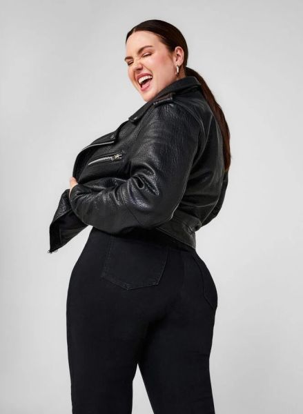 Sort plussize læderjakke med lynlåsdetaljer og matchende sorte jeans, designet til at fremhæve en moderne stil.