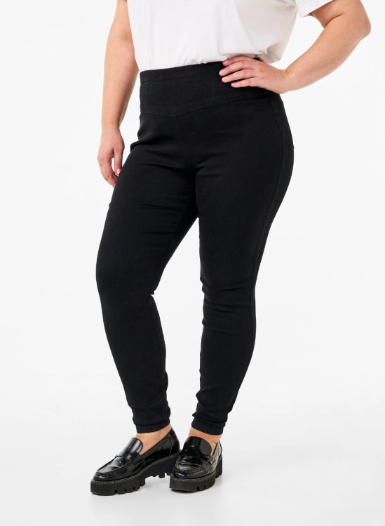 Sorte skinny jeans i plussize med høj talje og stretch, vist med sorte loafers. Perfekt til både casual og formelle lejligheder.