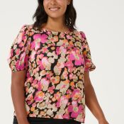 Blomstret plussize bluse i farverige nuancer med korte ærmer og rund hals, præsenteret på lys baggrund.