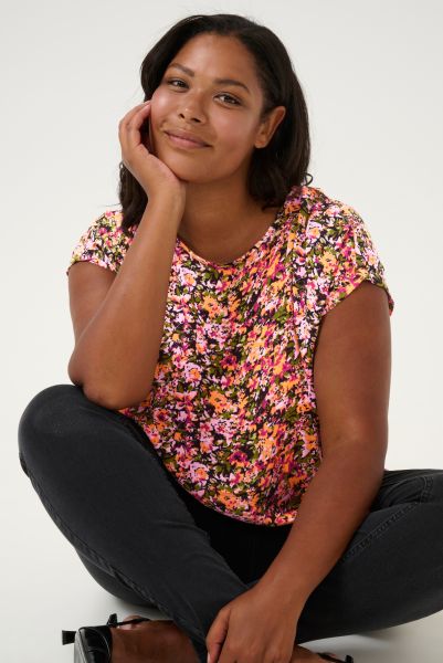 Blomstret plussize top med korte ærmer og sorte bukser, ideel til forårs- og sommerkollektionen i moderigtige plusstørrelser.