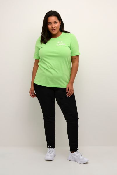 Neon grøn t-shirt med slogan og sorte slim-fit jeans præsenteret i plussize stil, perfekt til hverdagsbrug.
