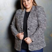 Plussize zebra-printet jakke i sort og hvid med knapper, kombineret med en enkel sort top og blå jeans.