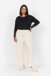 Plussize sort langærmet bluse med blondefor og bredbenede beige bukser præsenteret på hvid baggrund, moderne hverdagstøj til større størrelser.