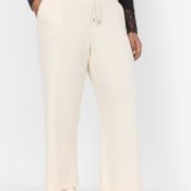Beige plussize bukser med snøre og lige ben, stylet med sorte detaljer og beige sneakers.