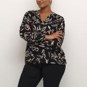 Elegant blomstret bluse med V-udskæring og sorte bukser, der viser et sofistikeret hverdagslook.