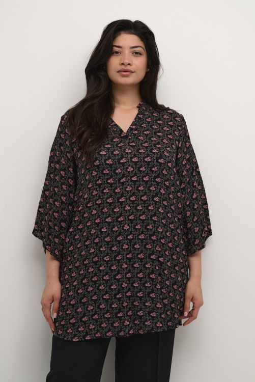 Loose-fit mønstret tunika i plusstørrelse med trekvart ærmer og v-hals, præsenteret med sorte bukser. Perfekt til hverdagsbrug.