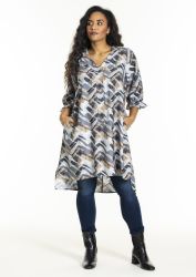 Trendy plussize tunika med geometrisk mønster, matchet med mørkeblå jeans og sorte ankelstøvler, velegnet til casual eller kontormode.