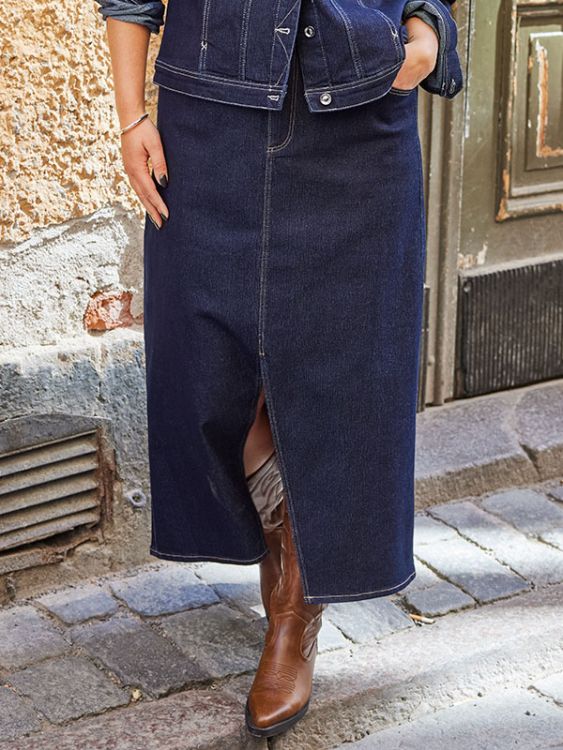 Lang denim nederdel med slids og matchende jakke kombineret med brune støvler, velegnet til plussize hverdagsmode.