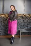 Plussize outfit med pink plissénederdel og brun læderjakke kombineret med sorte ankelstøvler. Stilfuldt hverdagstøj i store størrelser.