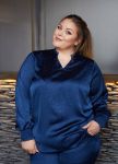 Elegant plussize blå mønstret bluse og bukser mod blødt baggrundslærred, ideel til hverdag eller kontor.