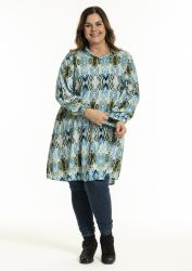 Plussize tunika med etnisk mønster, matchet med mørke jeans og sorte støvler, præsenteret på en hvid baggrund.