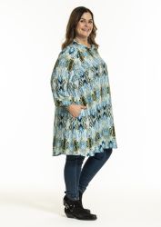 Plussize A-formet tunika fra Gozzip med etnisk mønster kombineret med slim-fit jeans og sorte ankelstøvler.