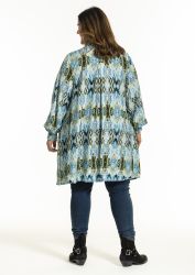 Plussize tunika med etnisk mønster i blålige nuancer, stylet med mørke skinny jeans og sorte ankelstøvler.