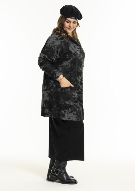 Sort og grå mønstret tunic ovenpå en sort nederdel med sorte ankelstøvler og matchende baret, ideel til plussize efterårs- og vintermode.