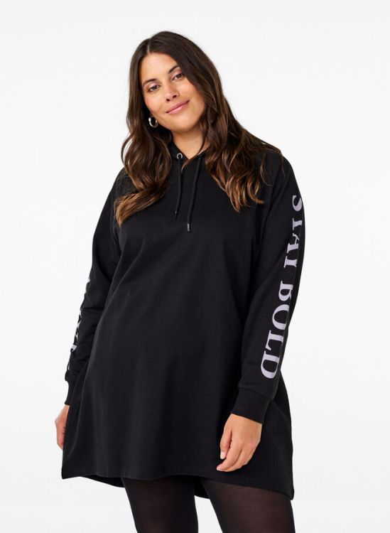 Sort plussize hættetrøje fra Zizzi med logotryk på ærmet, præsenteret stående med neutrale sorte strømpebukser.