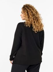 Sort bluse med lang ærme og rund hals set fra bagsiden på model med krøllet hår.