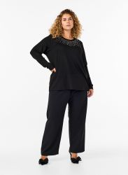 Sort plussize outfit med detaljeret bluse og brede bukser, perfekt til både arbejde og hverdag.