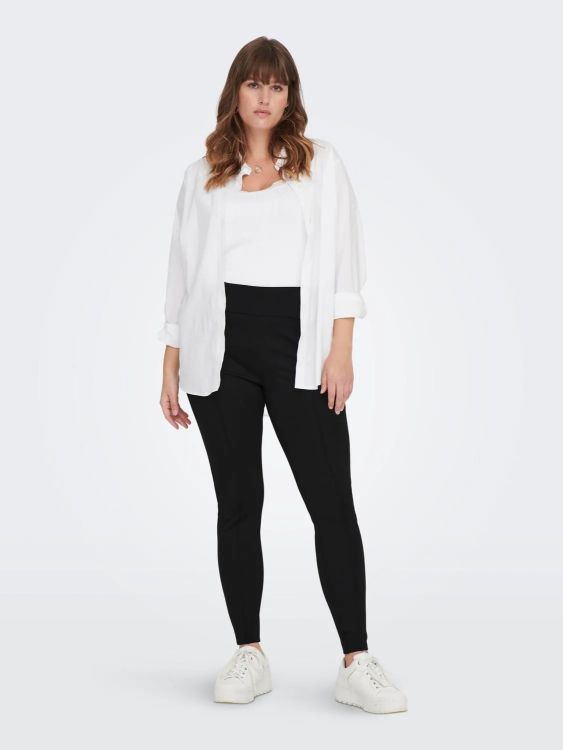 Moderne outfit med sorte bukser, kombineret med casual hvide sneakers. Perfekt til hverdagsbrug.