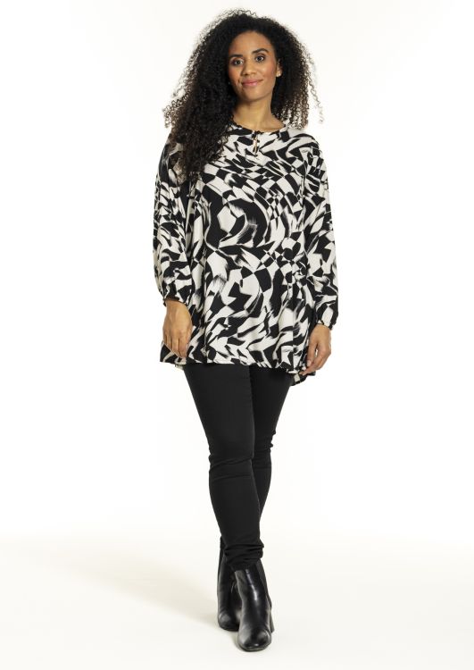 Plussize Studio tunika i sort og hvidt mønster med matchende sorte slim-fit bukser og elegante ankelstøvler.