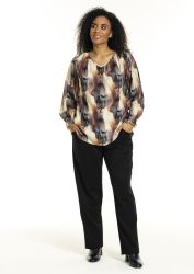 Studio plussize bluse i abstrakt print med løs pasform, kombineret med sorte klassiske bukser og elegante ankelstøvler.