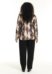 Elegant Studio plussize bluse med abstrakt print i jordfarver kombineret med sorte bukser, ideel til kontor eller uformelle sammenkomster.