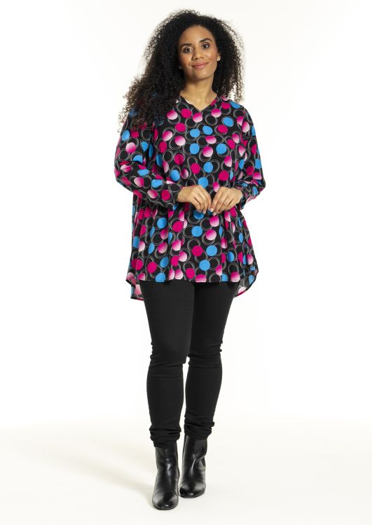 Farverig Studio tunika med cirkelmønster kombineret med sorte leggings og ankelstøvler. Stilfuldt tøjvalg til plussize.