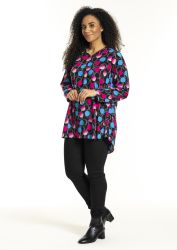 Studio mønstret tunika i plusstørrelse parret med sorte leggings og støvler for et moderne hverdagslook