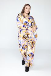 Mønstret plussize sæt med bukser og top i abstrakt design, stylet med sorte sko, egnet til størrelser 42-56.