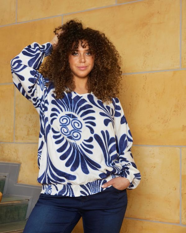 Zhenzi bluse i plussize med blå blomstermotiver på hvid baggrund, langærmet, perfekt til smart hverdagsbrug.