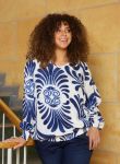 Mønstret bluse i plussize med blå blomstermotiver på hvid baggrund, langærmet, perfekt til smart hverdagsbrug.