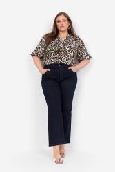 Model iført leopardmønstret bluse i plus-size stylet med mørke jeans.