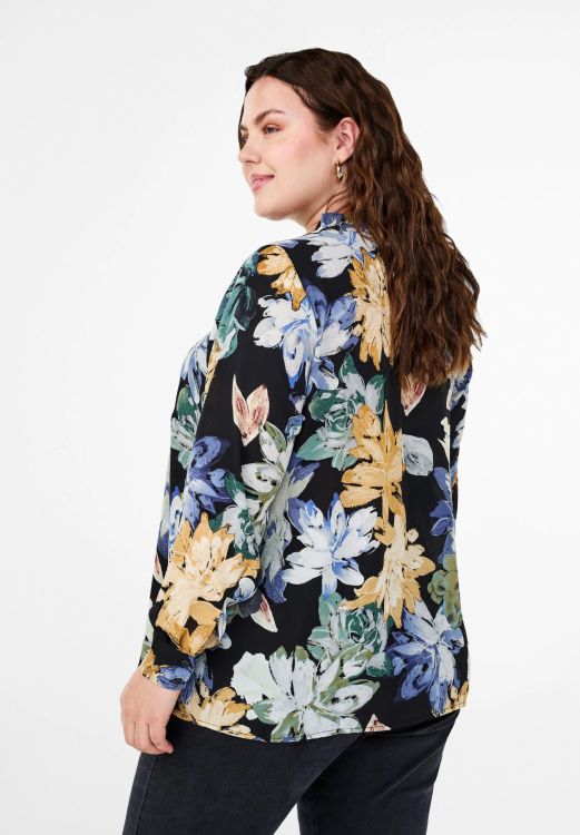 Elegant plussize outfit med blomstret bluse og behagelige jeans, ideel til hverdagsbrug. Stilrent og komfortabelt design.