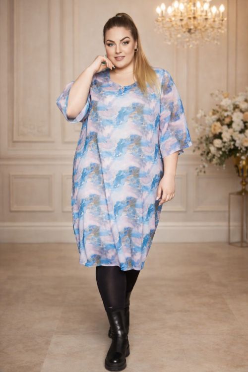 Plussize kjole med skyprint, halvlange ærmer og løs pasform, kombineret med sorte leggings og høje støvler.